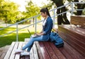 Young beautiful woman sitting outdoors using laptop computer. Royalty Free Stock Photo