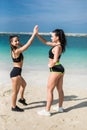 Young two sports women gives a high-five to each other outdoors on the beach Royalty Free Stock Photo