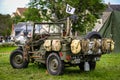 Image of an American army jeep in Normandy in a camp. Recreation on the 70th anniversary. Back view with tourists watching