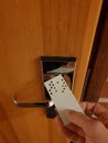 Image of analog punchcard as a key to open hotel room door Royalty Free Stock Photo