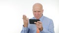 Image with Angry Businessman Reading Astonished Financial Bad News on Cellphone Royalty Free Stock Photo