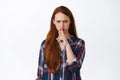 Image of angry ginger girl shushing, say shh and frowning displeased, prohibit, tell to be quiet, hush shut up, dont say