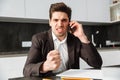 Angry young businessman talking by mobile phone. Royalty Free Stock Photo
