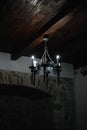 The image of an antique old iron chandelier hanging in the room. Metal chandelier in medieval