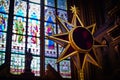 Image of an antique stained glass window on the background of a decorative, ornate cross