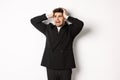 Image of anxious businessman start to panic, looking left with worried expression, standing in black suit over white