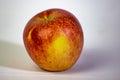 Image of an apple with a white background, the fruit is of those red and yellow but there are several colors depending on the qual