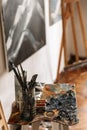 Image of artist workplace with painting tools and artworks on wall