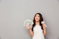 Image of asian content woman 20s holding fan of money dollar ban