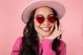 Image of asian girl with long dark hair wearing hat and sunglasses smiling Royalty Free Stock Photo