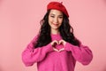 Image of asian girl smiling and showing heart shape with fingers Royalty Free Stock Photo