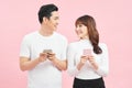 Image of asian man and woman using smartphones isolated over colorful background