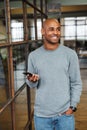 Image of attractive bald african american man holding cellphone in office Royalty Free Stock Photo