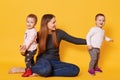 Image of attractive brown haired mother wants to be photographed with her sweet children, sit on floor in studio. Mother and girls