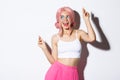 Image of attractive party girl with pink wig and bright makeup, having fun and celebrating holiday, dancing happy over