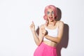 Image of attractive party girl with pink wig and bright makeup, having fun and celebrating holiday, dancing happy over