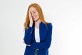 Image of attractive stylish red hair woman in blue style suit making facepalm, holding hand on eye and smiling, coming to terms