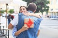 Image of attractive woman with present box giving hug to her man