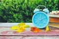 Image of autumn Time Change. Fall back concept. Dry leaves and vintage alarm Clock