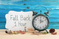 Image of autumn Time Change. Fall back concept. Dry leaves and vintage alarm Clock on rustic wooden table Royalty Free Stock Photo