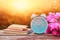 Image of autumn Time Change. Fall back concept. Dry leaves and vintage alarm Clock on wooden table