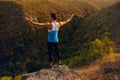 Image of a back athlete, fit, abs, sportive young man doing stretching exercises, on a mountain background.