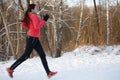 Image from back of brunette in sports uniform on morning run in winter Royalty Free Stock Photo