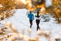 Image from back of running two athletes in winter park Royalty Free Stock Photo