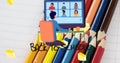 Image of back to school text with schoolboy using computer over coloured pencils on notebook Royalty Free Stock Photo