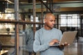 Image of bald african american man holding laptop while working in office Royalty Free Stock Photo