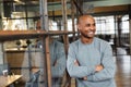 Image of bald african american man standing with arms crossed in office Royalty Free Stock Photo