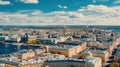 Image is beautiful aerial view of city, with buildings and trees lining streets. There are several cars parked along