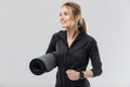 Image of beautiful blond woman 20s dressed in sportswear carrying yoga mat while walking Royalty Free Stock Photo