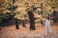 Image of a beautiful brunette woman in a red beret walks in the park in autumn
