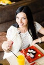 Image of beautiful brunette young woman eating tasty sushi having fun happy smiling sitting in restaurant & looking at camera Royalty Free Stock Photo