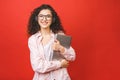Image of beautiful curly woman listening to music or chatting using headphones and laptop isolated over red wall background Royalty Free Stock Photo
