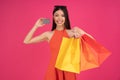 Image of a beautiful excited happy asian woman posing isolated over pink wall background holding shopping bags and credit card. Royalty Free Stock Photo
