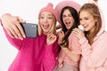 Image of beautiful girls smiling and taking selfie photo on cellphones Royalty Free Stock Photo