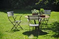 Image of beautiful green garden with antique chairs.