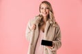 Beautiful happy young pretty woman posing isolated over pink wall background showing display of mobile phone Royalty Free Stock Photo