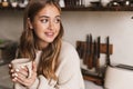 Image of beautiful nice woman drinking coffee and looking aside