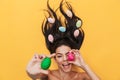 Pleased happy young woman lies isolated on yellow background over easter eggs Royalty Free Stock Photo