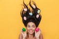 Pleased happy young woman lies isolated on yellow background over easter eggs Royalty Free Stock Photo