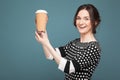 Image of beautiful woman in speckled clothes standing with coffe in hands