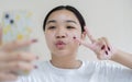 Image of beautiful young Asian girl laughing and showing peace sign while taking selfie photo Royalty Free Stock Photo