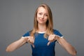 Image of Beautiful young female looking is upset at the camera, holding two thumbs down. Concept of dislike Royalty Free Stock Photo