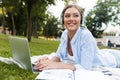 Young pretty woman in park outdoors using laptop computer listening music. Royalty Free Stock Photo