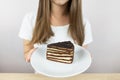 image of a beautiful young woman holding a piece of chocolate cake in a plate