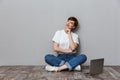 Image of beautiful young woman sitting on floor with laptop computer Royalty Free Stock Photo