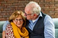 Senior Couple Enjoying Close Moment on Sofa Royalty Free Stock Photo